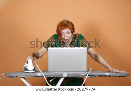Woman surfing the internet on her laptop and iron with astonishment
