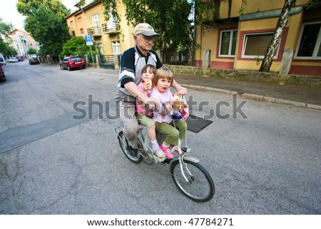 ZAGREB - JUNE 05: Grand father transporting his grand children, Emma and Ivana, 4, from Zagreb, by bike on June 05, 2009 in Zagreb, Croatia. People are finding non-polluting alternatives to cars.