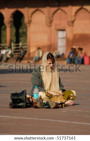 DEHLI - FEBRUARY 11. Western tourist dressed in traditional clothing at Jama Masjid mosque on February 11, 2008 in Dehli, India. It\'s the largest mosque in India with millions of visitors each year.