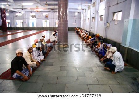 DELHI - SEPTEMBER 22:  Men waiting for free meal in langer dining hall in Sikh temple on September 22, 2007 in Delhi, India. Sikh temples can serve thousands of free meals everyday.