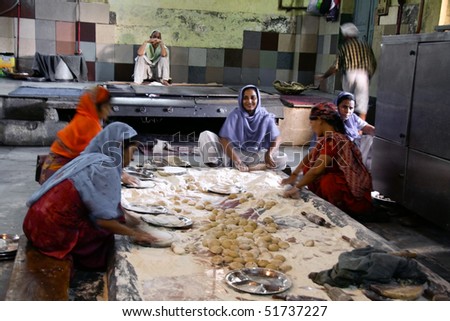 DELHI - SEPTEMBER 22:  Women preparing food in Sikh temple kitchen on September 22, 2007 in Delhi, India. Sikh temples can serve thousands of free meals everyday.