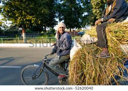 DELHI - FEBRUARY 12: Two men transporting grass using a rickshaw bicycle on February 12, 2008 in Delhi, India. Most Indians cannot afford motorized vehicles.