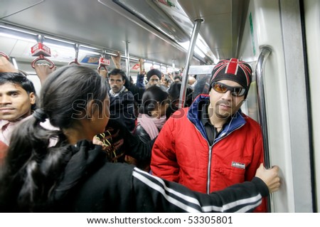 DELHI - JANUARY 19: Men and women standing in crowded train carriage on January 19, 2008 in Delhi, India. Nearly 1 million passengers use the metro daily.
