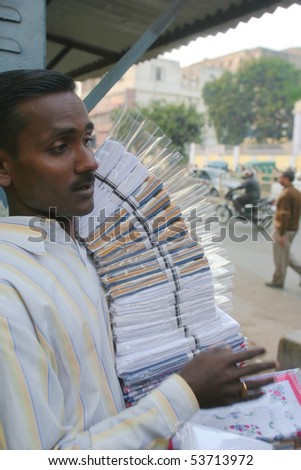 DELHI - JAN 19: Young man in street market selling wrapped linen goods on January 19, 2008 in Delhi, India. Most shopping life happens in outdoor markets, unlike in the West.