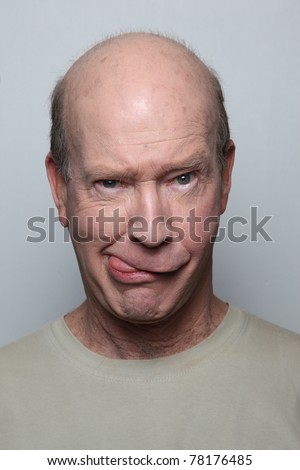 Man making funny face sticking out tongue - stock photo