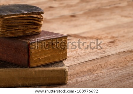 old book stack, brown pages blank spine, macro of aged library heap on table