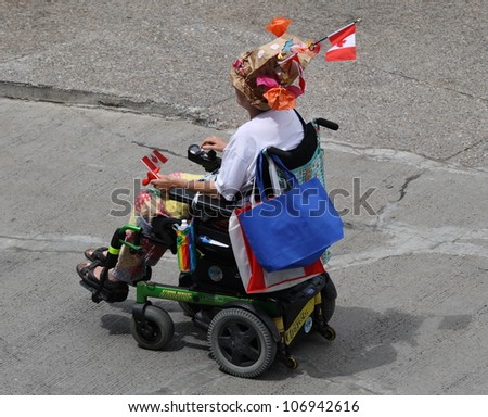 OTTAWA, CANADA - JULY 1: An elderly woman in a motorized wheelchair on Canada Day, July 1, 2012 in Ottawa, Ontario. Canada Day is a national holiday and is celebrated each July 1st across the country.
