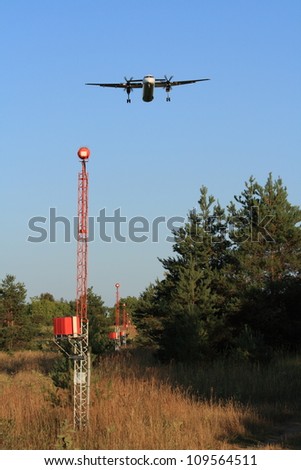 A plane flying over an approach lighting system during its landing approach.