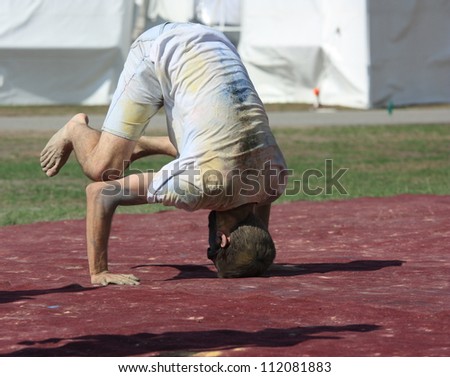 OTTAWA, CANADA - AUGUST 12: A man light-heartedly attempting a head stand during a holi celebration at the inaugural Festival of India on August 12, 2012 in Ottawa, Ontario.