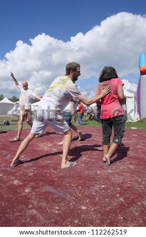 OTTAWA, CANADA - AUGUST 11: People playing during a holi celebration at the Festival of India on August 11, 2012 in Ottawa, Ontario. Holi is like a game of tag but uses colored powders and water.