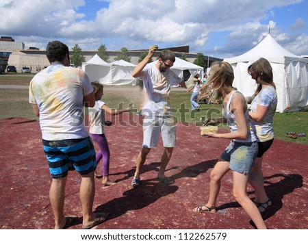 OTTAWA, CANADA -Â?Â? AUGUST 12: People throwing colored powders during holi at the Festival of India on August 12, 2012 in Ottawa, Ontario. Holi is like a game of tag but uses colored powders and water.