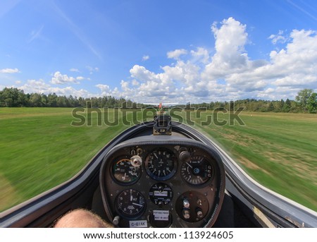 The view from inside a glider as it is being towed by another plane down a grass airfield in Manotick, Ontario, Canada.