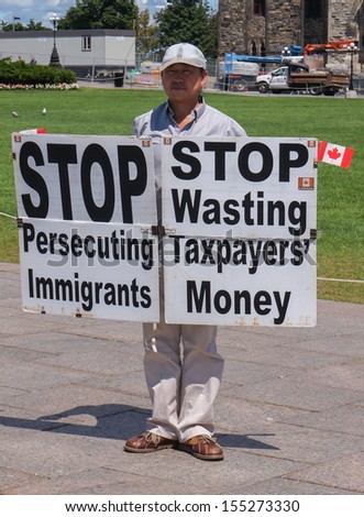 OTTAWA, CANADA - AUGUST 10, 2013: A man protesting with signs on Parliament Hill on August 10, 2013 in Ottawa, Ontario.
