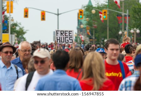 OTTAWA, CANADA - JULY 1: A sign with \'FREE HUGS\' being held up during Canada Day on July 1, 2013 in downtown Ottawa, Ontario.