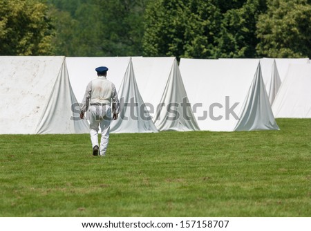 MORRISBURG, CANADA - JULY 14: A man in period costume walks towards an encampment during the Battle of Crysler\'s Farm reenactment on July 14, 2013 near Morrisburg, Ontario.