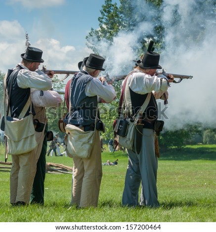 MORRISBURG, CANADA - JULY 14: Men firing guns together during the Battle of Crysler\'s Farm reenactment on July 14, 2013 near Morrisburg, Ontario.