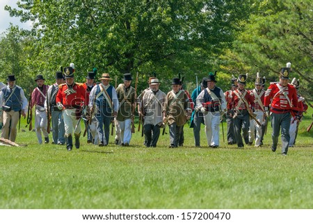 MORRISBURG, CANADA - JULY 14: Men running across a field during the Battle of Crysler's Farm reenactment on July 14, 2013 near Morrisburg, Ontario.