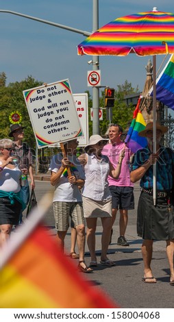 OTTAWA, CANADA - AUGUST 26: People walking with placards in the Capital Pride Parade on August 26, 2012 in Ottawa, Ontario.