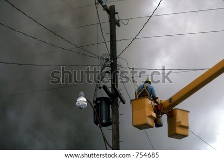 A man about to disconnect hydro wires during a house fire. Ottawa, Ontario.