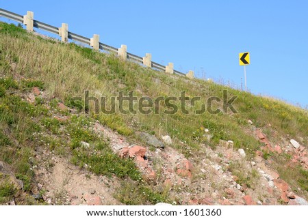 Highway embankment with turn left caution sign. Ontario.