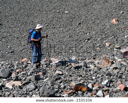 Man hiking on rocks beside a scree slope. Ring Mountain. British Columbia. Canada.