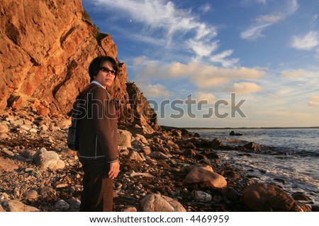 A Filipino woman on an ocean beach in Cape Breton Highlands National Park during the evening. Nova Scotia. Canada.