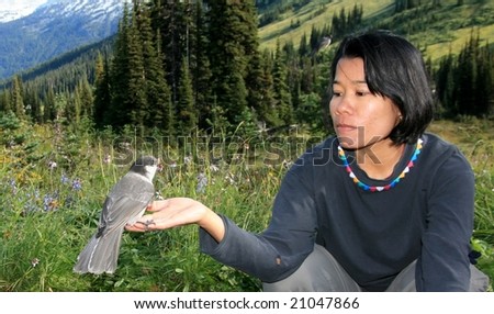 A woman with a whiskey jack in Garibaldi Provincial Park, British Columbia, Canada.