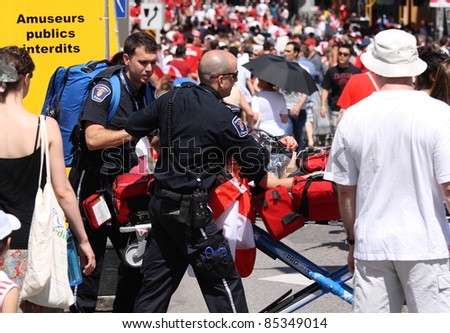 OTTAWA, CANADA – JULY 1: A woman is taken through the crowd by stretcher on July 1, 2011 in downtown Ottawa, Ontario. Several people had succumbed to the heat while waiting to see William and Kate.