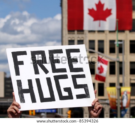 A man holding up a \'Free Hugs\' sign on Canada Day in downtown Ottawa, Ontario, Canada.
