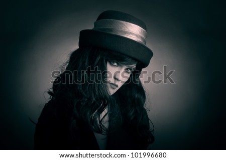 Brunette fashion woman in black hat. Portrait of young looking gothic woman