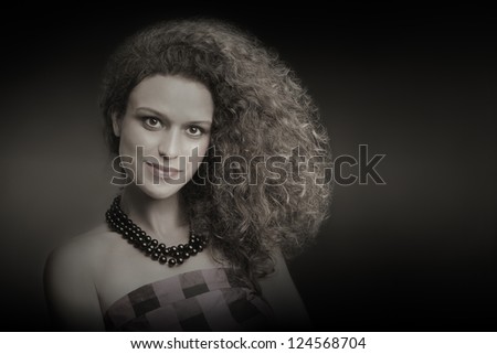 Curly thick hair woman hairstyle. Young pretty woman fashion portrait