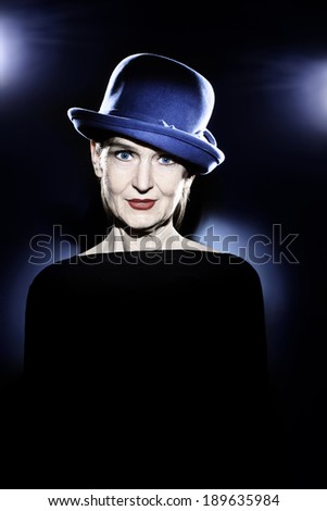 Senior woman in hat studio portrait. Pretty mature lady 60 years old with wrinkled face