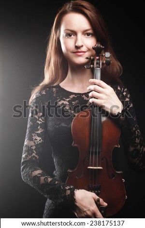 Portrait of beautiful woman with violin Player violinist with music instrument.