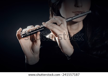 Flute piccolo with hands closeup playing music instrument