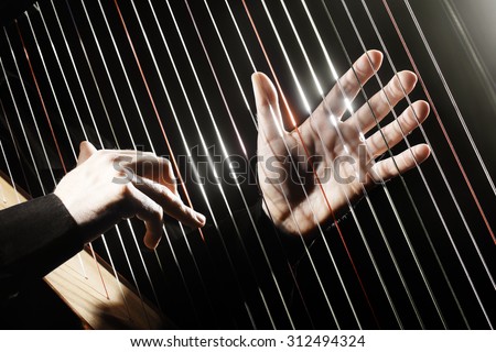 Harp strings closeup hands. Harpist with Classical Music Instrument