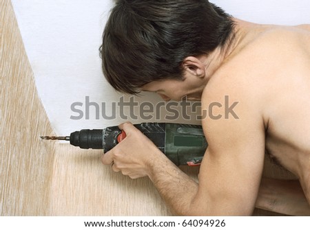 Homework. Man with drill drilling the wall.