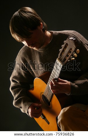 Guitarist. Man playing guitar on black background