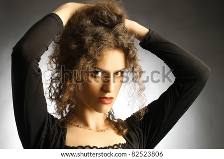 Fashion portrait of beautiful woman elegant brunette with hands on the brown hair