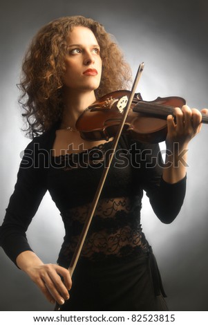 Violin playing beautiful woman violinist musician on black background