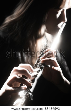 Musical instrument flute playing. Flutist on the black