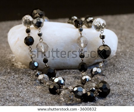 Black and silver necklace on a white stone