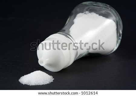 A shaker on its side spilling the salt