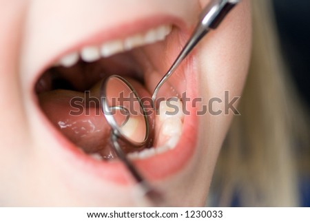 Dentist inspecting a child\'s teeth