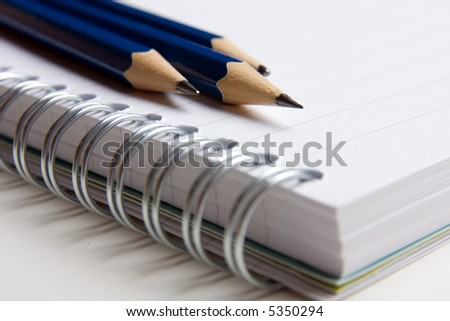 A spiral ring bound pad and three pencils
