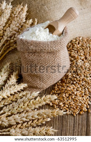 Wheat ears and flour in burlap bag