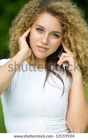 A beautiful young girl listening to music outside