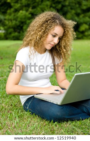 A beautiful young woman using a portable computer outside