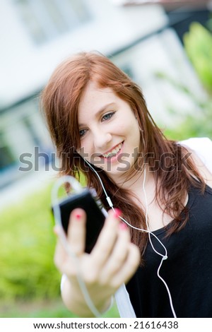 A young girl chilling to music outside
