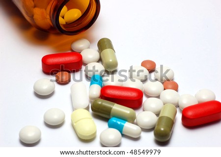 Spilled capsules and pills from  prescription glass bottle