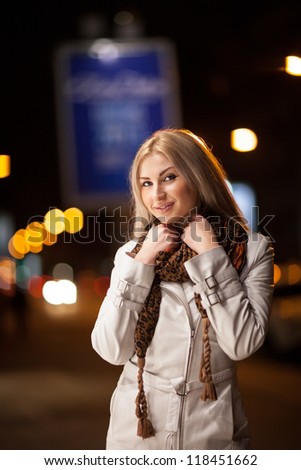 Beautiful girl walk through a night city street